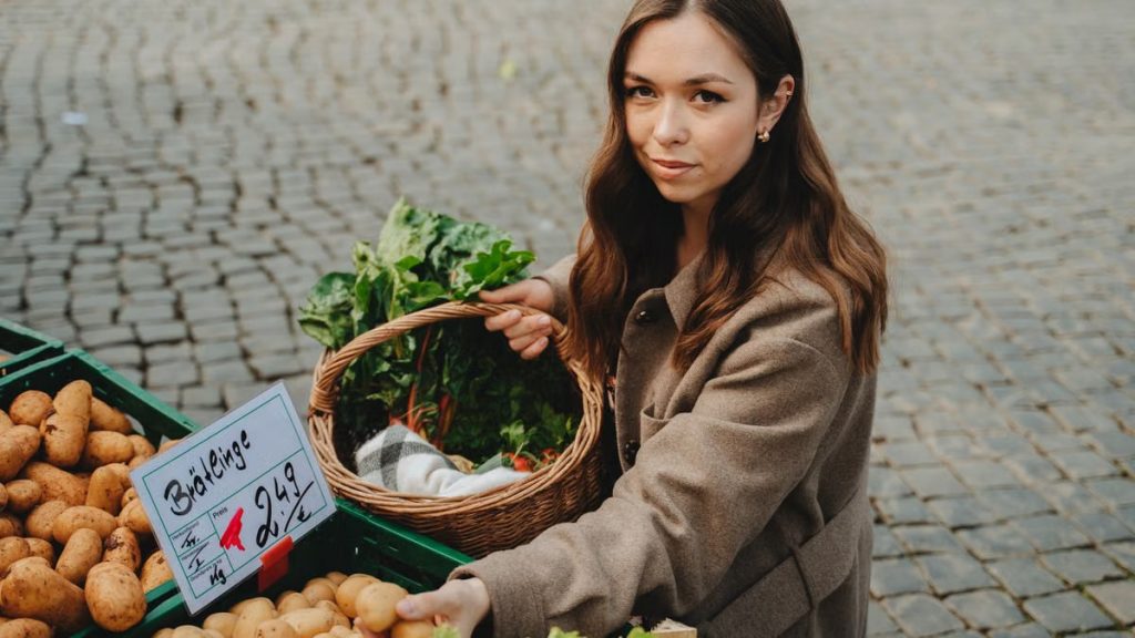 Young woman shopping at Erfurt farmers market, holding basket with fresh vegetables. Capturing local shopping culture.